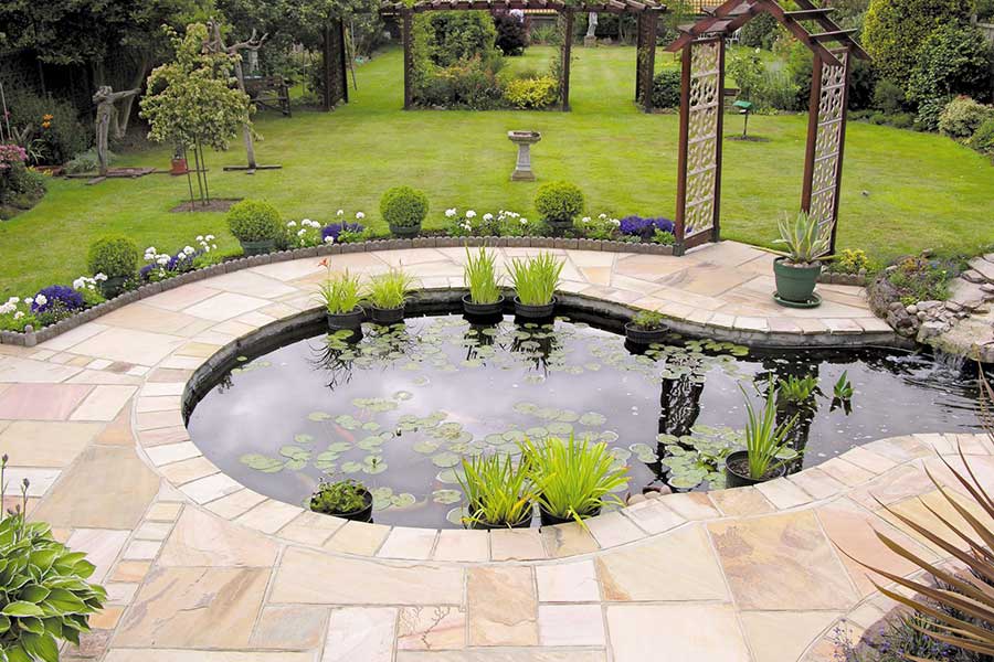Feature garden pond with Global Stone Country Fossil Mint Sandstone paving